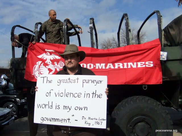 James M. Branum stands beside a Marines truck holding a sign with a quote from Martin Luther King Jr. Branum's group, the Oklahoma Center for Conscience, and the Marines were both participating in the 2011 King Holiday Parade in Oklahoma City. 